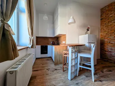a kitchen with a table and a white refrigerator at Dąbrowskiego 15 by Homeprime in Kraków