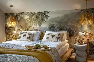 a bedroom with a mural of palm trees on the wall at Mucharskie Wzgórze in Mucharz