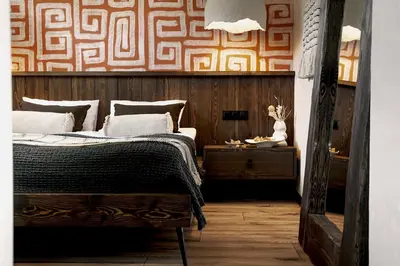 a bedroom with a bed and a wooden wall at Mucharskie Wzgórze in Mucharz