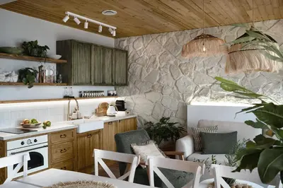a kitchen with a stone wall with a counter and chairs at Mucharskie Wzgórze in Mucharz