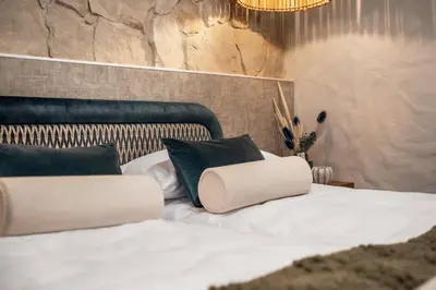 a bedroom with a white bed with black pillows at Mucharskie Wzgórze in Mucharz