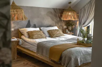 a bedroom with a bed with white sheets and gold pillows at Mucharskie Wzgórze in Mucharz