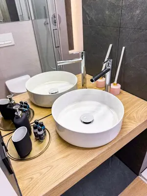 a bathroom with two sinks on a wooden counter at Dozen Kittens Apartment in Kraków