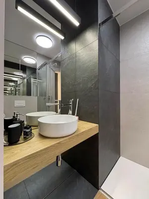 a bathroom with a sink and a large mirror at Dozen Kittens Apartment in Kraków