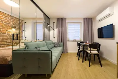 a living room with a couch and a table at Dozen Kittens Apartment in Kraków