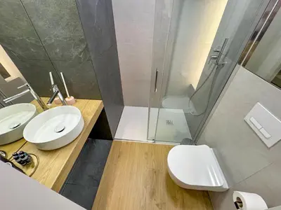 a bathroom with a shower and a toilet and a sink at Dozen Kittens Apartment in Kraków