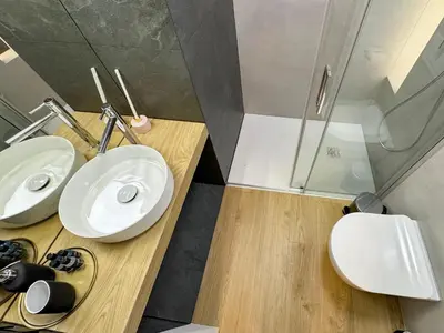 a bathroom with two white sinks and a shower at Dozen Kittens Apartment in Kraków