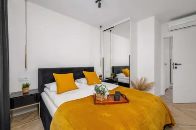 a bedroom with a large bed with yellow pillows at Luksusowy, Klimatyzowany Apartament w Krakowie z Biurkiem i Parkingiem by Renters Prestige in Kraków