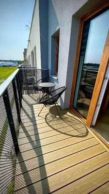 a wooden deck with a table and chairs on a balcony at Luksusowy, Klimatyzowany Apartament w Krakowie z Biurkiem i Parkingiem by Renters Prestige in Kraków