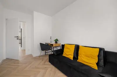 a living room with a black couch with yellow pillows at Luksusowy, Klimatyzowany Apartament w Krakowie z Biurkiem i Parkingiem by Renters Prestige in Kraków