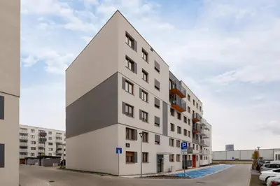 a tall white building with a pointed roof at Luksusowy, Klimatyzowany Apartament w Krakowie z Biurkiem i Parkingiem by Renters Prestige in Kraków
