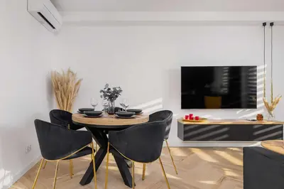 a dining room with a table and chairs and a tv at Luksusowy, Klimatyzowany Apartament w Krakowie z Biurkiem i Parkingiem by Renters Prestige in Kraków