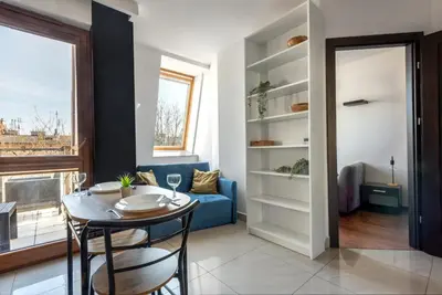 a living room with a table and a blue couch at Charming Apartment with Air Conditioning for couples in the city center in Kraków