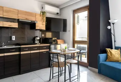 a kitchen with a small table and a blue couch at Charming Apartment with Air Conditioning for couples in the city center in Kraków