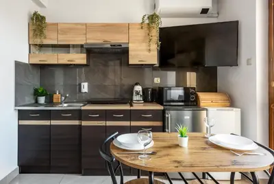 a kitchen with a wooden table with two chairs at Charming Apartment with Air Conditioning for couples in the city center in Kraków