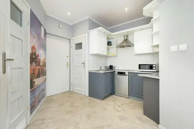 a kitchen with white cabinets and blue appliances at Bright Apartment Near Old Town and Wawel by Noclegi Renters in Kraków