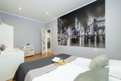 a bedroom with a large picture on the wall at Bright Apartment Near Old Town and Wawel by Noclegi Renters in Kraków