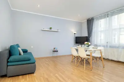 a living room with a couch and a table and chairs at Bright Apartment Near Old Town and Wawel by Noclegi Renters in Kraków