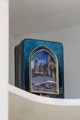 a book on a shelf with a picture of a castle at Bright Apartment Near Old Town and Wawel by Noclegi Renters in Kraków