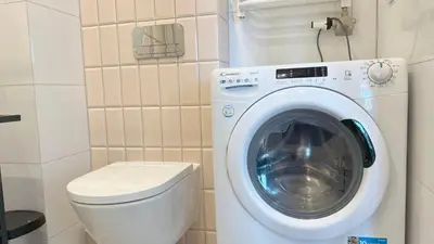 a small bathroom with a washing machine and a toilet at RoseKrak in Kraków