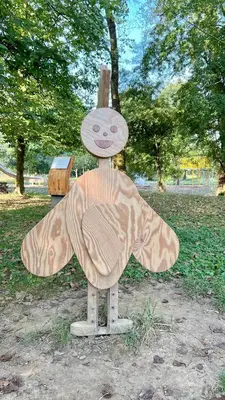a wooden statue of a bee with a wooden box at RoseKrak in Kraków