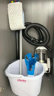a water hose is in a bucket next to a sink at RoseKrak in Kraków