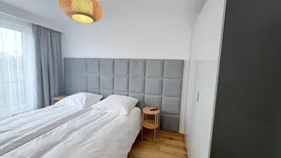 a bedroom with a large white bed and a window at RoseKrak in Kraków