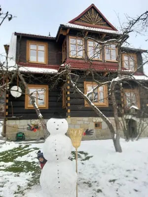 a snowman in front of a log house at Willa Świt in Maków Podhalański