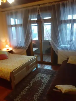 a bedroom with a bed and a window with curtains at Willa Świt in Maków Podhalański