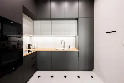 a kitchen with black and white cabinets and a sink at Native Apartments Rajska 6 in Kraków