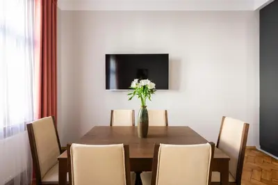 a dining room table with a vase of flowers on it at Native Apartments Rajska 6 in Kraków