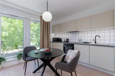 a kitchen with a table and two chairs and a table at inQse Krakow Centre in Kraków