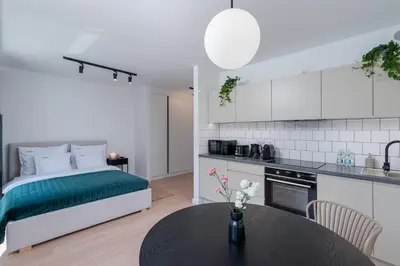 a kitchen and a bedroom with a bed and a table at inQse Krakow Centre in Kraków