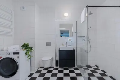 a bathroom with a sink and a washing machine at inQse Krakow Centre in Kraków
