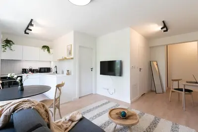 a living room with a table and a kitchen at inQse Krakow Centre in Kraków