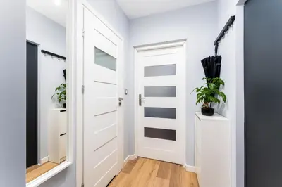 a white door in a hallway with plants at Forest House by Cozyplace in Kraków