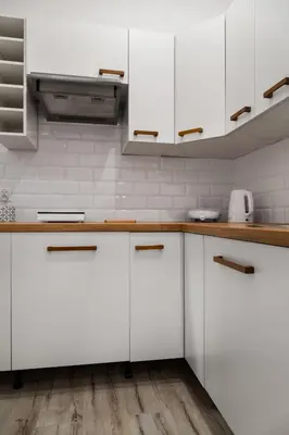 a kitchen with white cabinets and wooden counter tops at Househost Apt Starowislna 75-2 in Kraków
