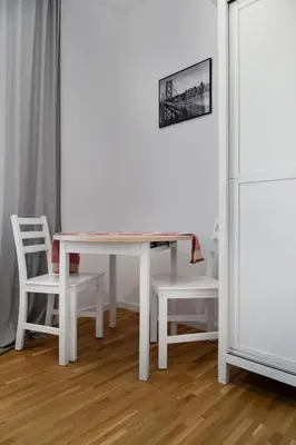 a white table with two chairs and a white refrigerator at Househost Apt Starowislna 75-2 in Kraków