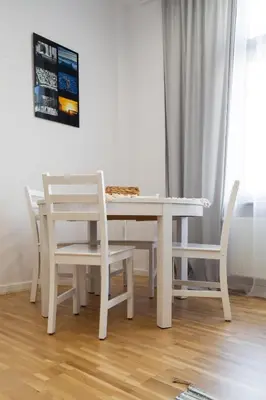 a white dining room table with white chairs and a table at Househost Apt Starowislna 75-2 in Kraków