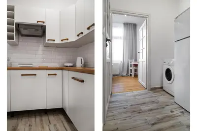a kitchen with white cabinets and a washer and dryer at Househost Apt Starowislna 75-2 in Kraków