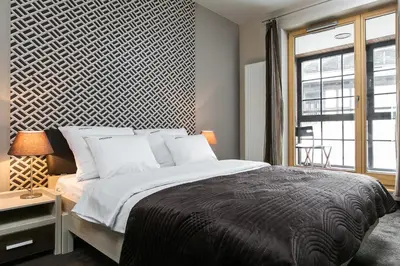 a bedroom with a large bed and a window at inQse Krakow Brewery Residence in Kraków