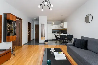 a living room with a couch and a table at inQse Krakow Brewery Residence in Kraków