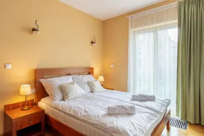 a bedroom with a bed and a wooden cabinet at BIG Prestige Apartment - 6 min Main Square Kraków in Kraków