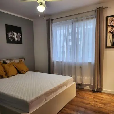 a bedroom with a large bed and a window at Korczaka Apartments Prokocim in Kraków