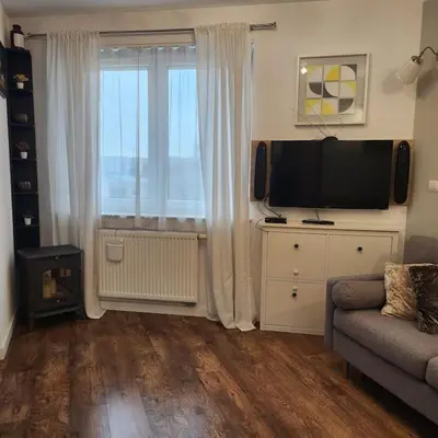 a living room with a couch and a television at Korczaka Apartments Prokocim in Kraków