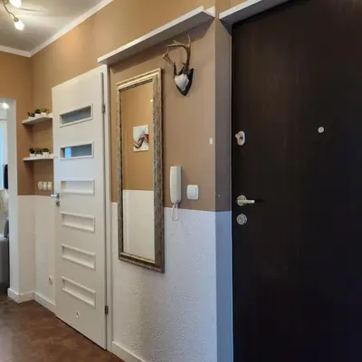 a bathroom with a door and a mirror on the wall at Korczaka Apartments Prokocim in Kraków