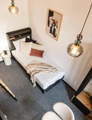 a bedroom with a bed with white sheets and pillows at Vilao Apartments- Łazarza in Kraków