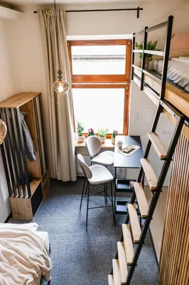 a room with a table and chairs and a bunk bed at Vilao Apartments- Łazarza in Kraków