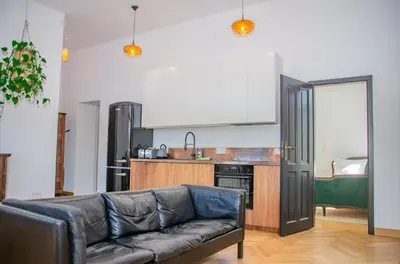 a living room with a couch and a kitchen at InPoint Royal Wawel View & Old Town Apartment Self Check-in in Kraków