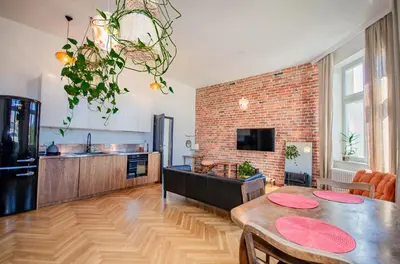 a kitchen and living room with a dining table and a brick wall at InPoint Royal Wawel View & Old Town Apartment Self Check-in in Kraków